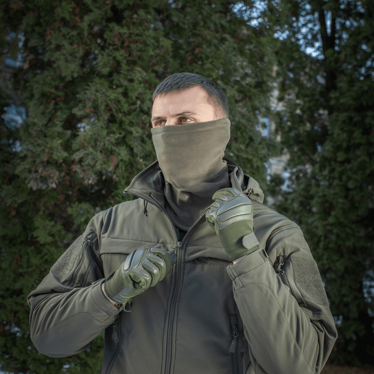 Mand iført M-Tac Polartec Anatomic Tube Scarf i skovmiljø, beskytter mod vind, Polartec® Micro Series fleece, multifunktionelt tørklæde.