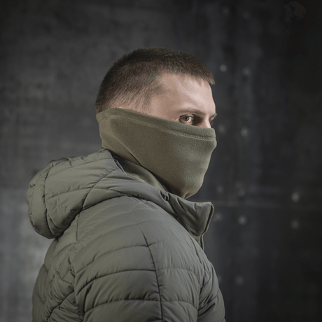 En mand bærer M-Tac Polartec Anatomic Tube Scarf for beskyttelse mod vind, lavet af Polartec® Micro Series fleece, til udendørs brug.