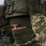 Person iført M-Tac Rip-Stop Fleece Hjelmliner og militær hjelm i koldt vejr