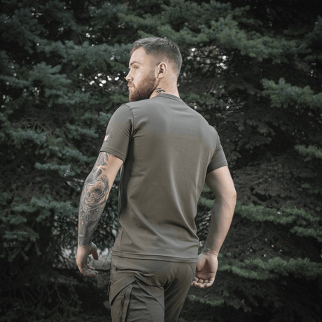 Mand iført M-Tac Sniper T-shirt i skovmiljø, bagfra, viser pasform og tætsiddende design