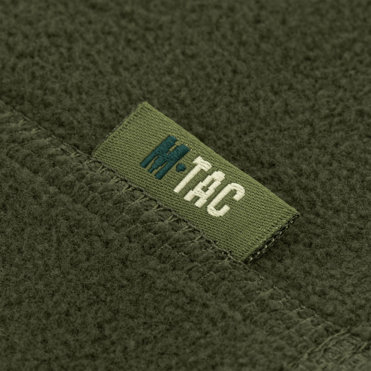 Nærbillede af M-Tac Snood Elite Kort Justerbar Fleece mærke på grønt fleecestof