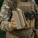 M‑Tac Tourniquet Pouch Elastic Gen.5 holdt af taktisk udstyret soldat, viser robust Cordura-materiale og praktisk design til CAT tourniquet.