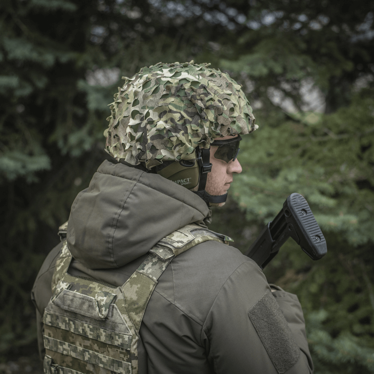 Soldat iført M‑Tac Vilha Hjelmcover Elite i MULTICAM-camouflage for beskyttelse og skjul i naturen, designet til FAST hjelme.