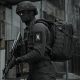 Taktisk operatør iført "M-Tac Patch Bad Boy (Broderi)" med kaninkranium på ace of spades kort, holdende våben, i urban indstilling.